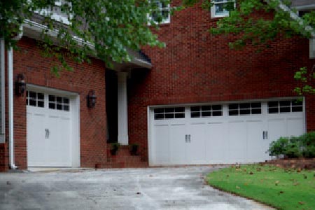 A brown large house with three garage doors